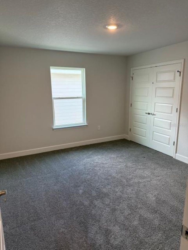 2214 NW 23rd Loop, Ocala, FL 34475 - unfurnished bedroom featuring carpet flooring, a textured ceiling, and a closet