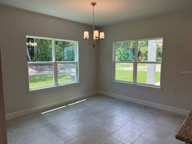 2214 NW 23rd Loop, Ocala, FL 34475 - unfurnished room with plenty of natural light, a chandelier, and tile patterned flooring