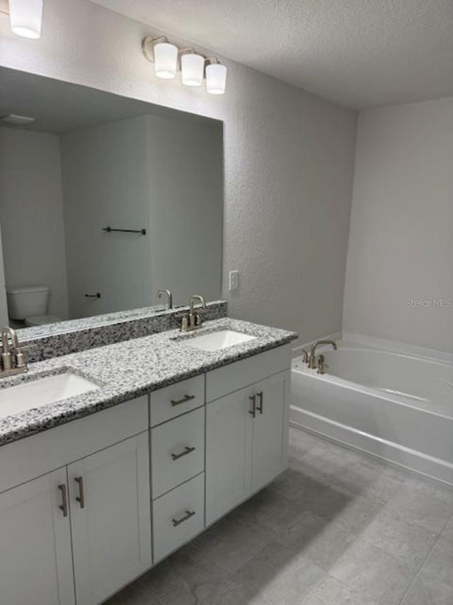 2214 NW 23rd Loop, Ocala, FL 34475 - full bath featuring a textured ceiling, double vanity, a bath, and a textured wall