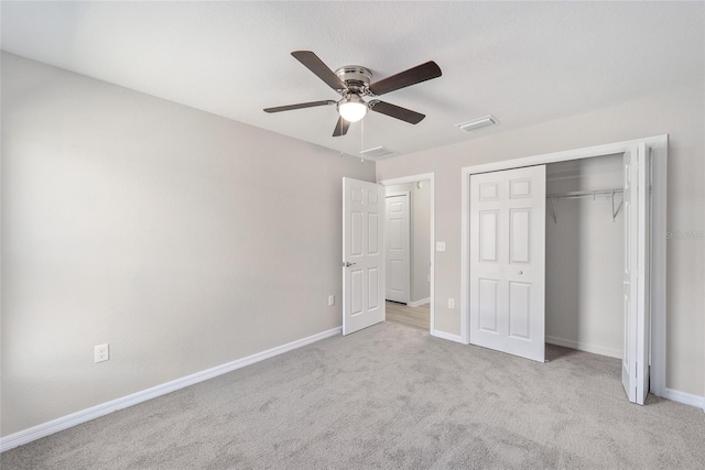 unfurnished bedroom featuring ceiling fan, light colored carpet, and a closet