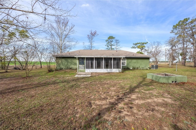 rear view of house with a lawn and a sunroom