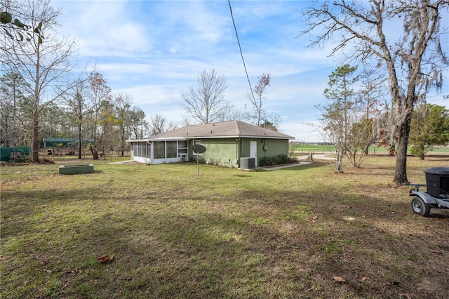 view of yard with a sunroom and central AC