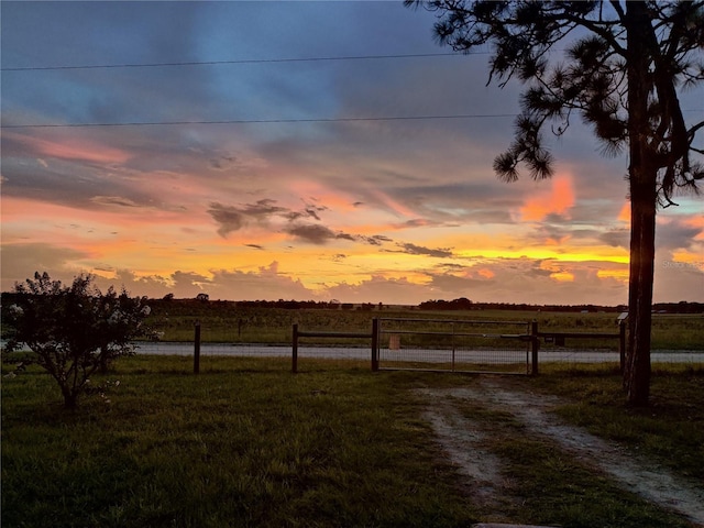 yard at dusk featuring a rural view