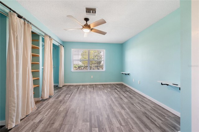 unfurnished bedroom featuring light wood-type flooring, ceiling fan, a closet, and a textured ceiling