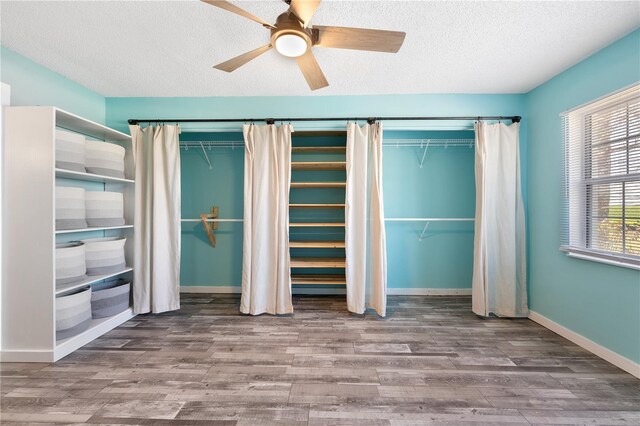 unfurnished bedroom featuring ceiling fan, a textured ceiling, and hardwood / wood-style flooring