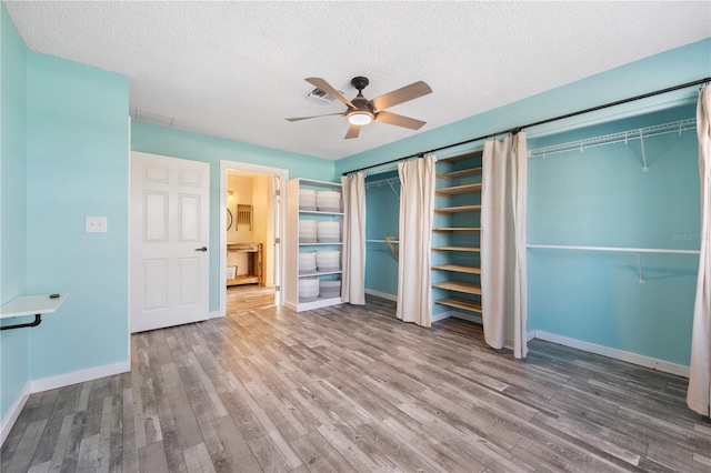 unfurnished bedroom with a textured ceiling, ceiling fan, and hardwood / wood-style floors