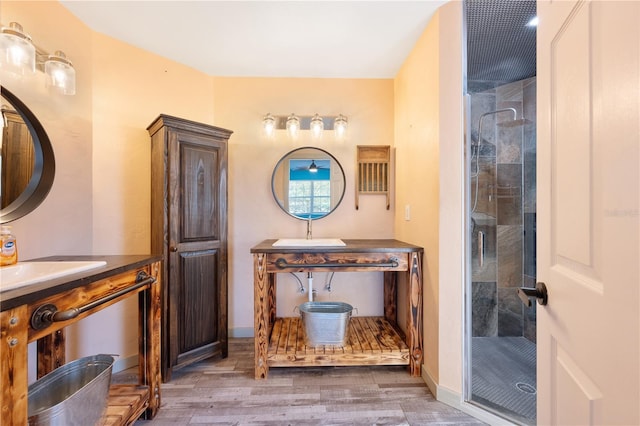 bathroom with a shower with shower door, wood-type flooring, and sink