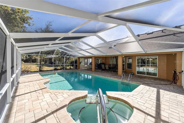 view of swimming pool with an in ground hot tub, glass enclosure, and a patio