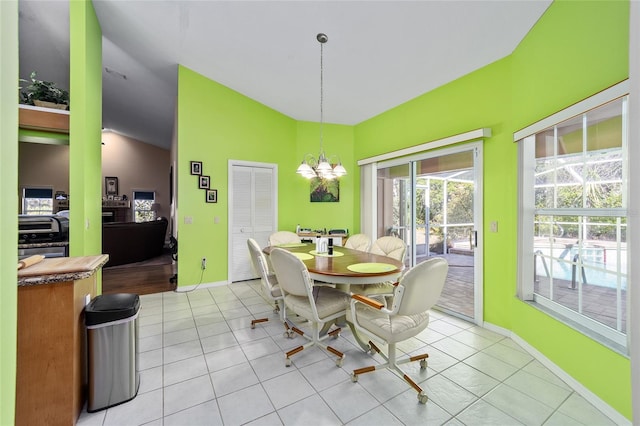 tiled dining area with an inviting chandelier and lofted ceiling