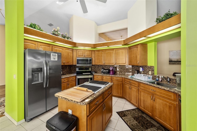 kitchen featuring tasteful backsplash, appliances with stainless steel finishes, sink, and a kitchen island