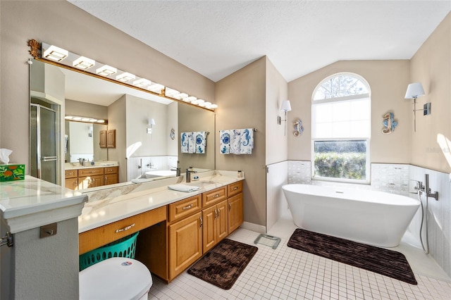 bathroom featuring lofted ceiling, vanity, tile patterned flooring, and shower with separate bathtub