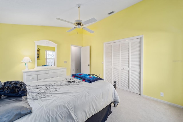 carpeted bedroom with ceiling fan, lofted ceiling, and a closet