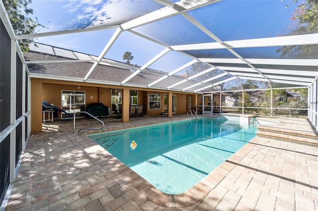 view of pool with a patio and glass enclosure