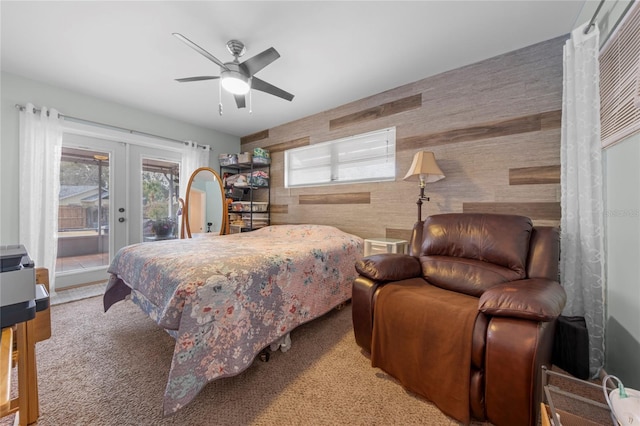 bedroom with carpet floors, french doors, wood walls, access to outside, and ceiling fan