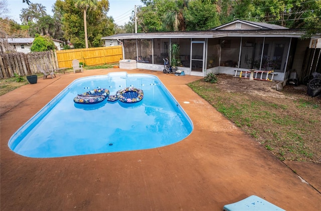 view of swimming pool featuring a sunroom and a patio