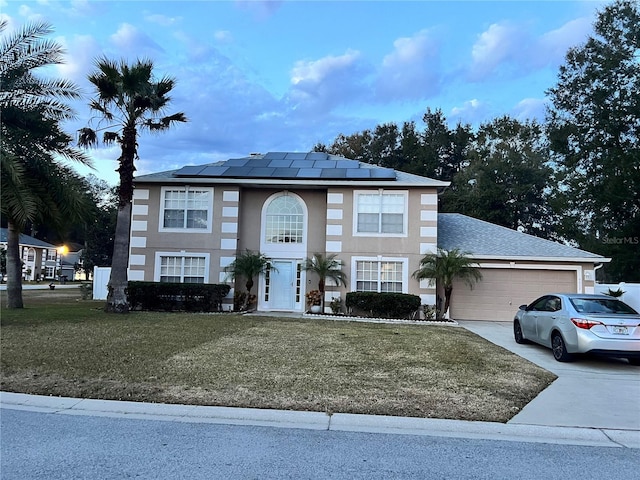 view of front of property featuring a front lawn, solar panels, and a garage