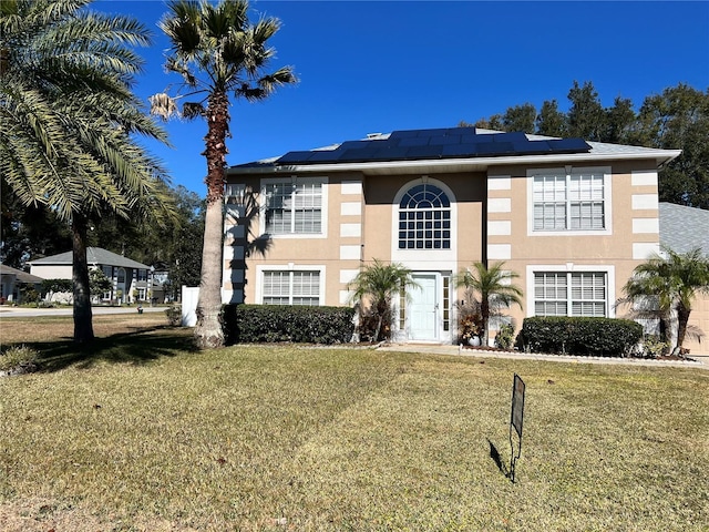 view of front of property featuring a front lawn and solar panels