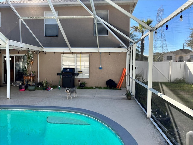 rear view of house featuring a fenced in pool, a patio, and a lanai