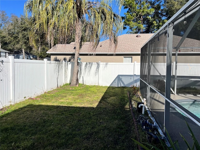 view of yard with a fenced in pool and glass enclosure