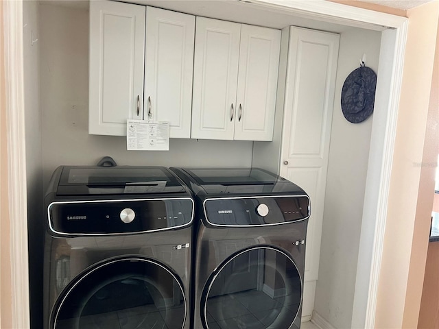 laundry room featuring cabinets and washing machine and clothes dryer