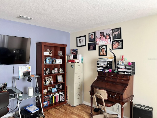 office space with light hardwood / wood-style flooring and a textured ceiling