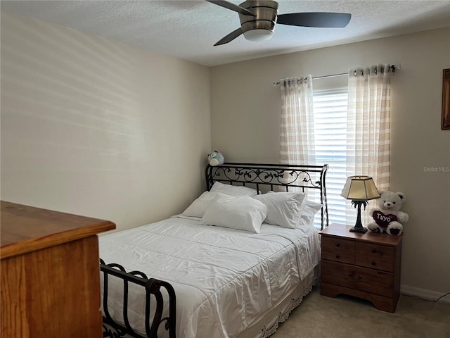 carpeted bedroom featuring a textured ceiling and ceiling fan