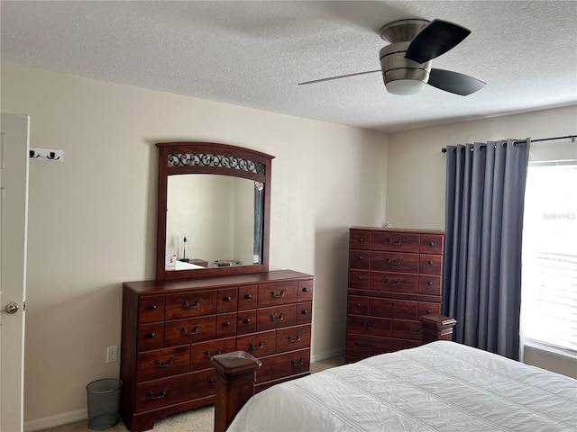 carpeted bedroom featuring ceiling fan, multiple windows, and a textured ceiling