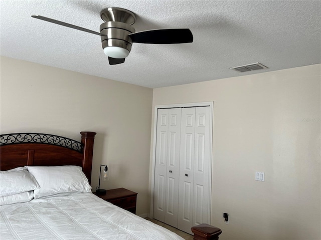 bedroom featuring ceiling fan, a closet, and a textured ceiling