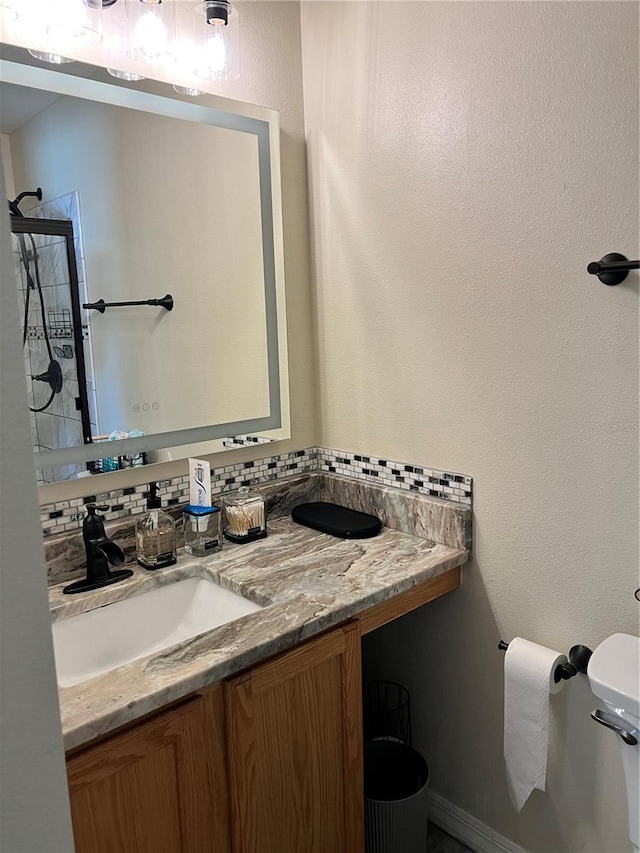 bathroom with vanity, toilet, and decorative backsplash