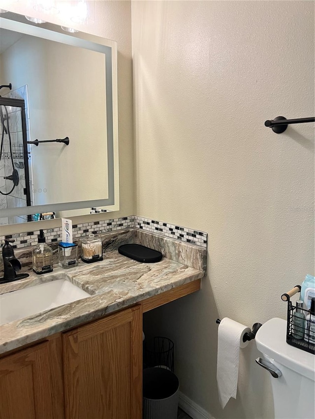 bathroom featuring vanity, toilet, and a shower