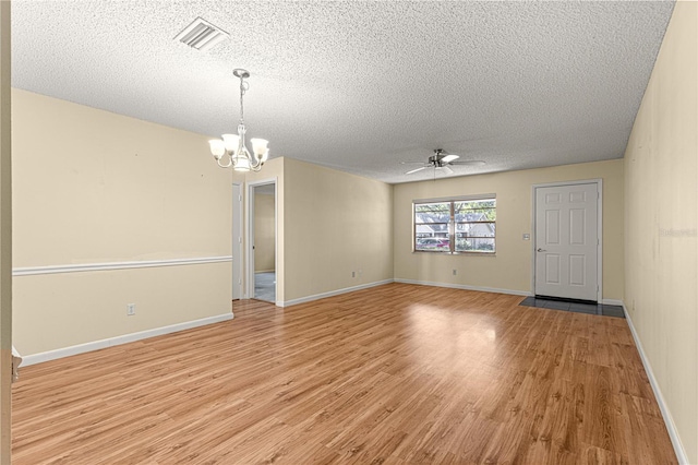 spare room with ceiling fan with notable chandelier, a textured ceiling, and light hardwood / wood-style floors