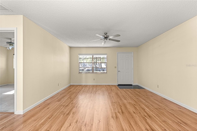 empty room with light hardwood / wood-style floors, a textured ceiling, and ceiling fan