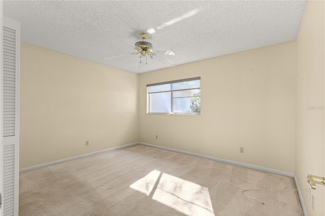 unfurnished room featuring ceiling fan, light carpet, and a textured ceiling