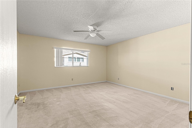 carpeted spare room with a textured ceiling and ceiling fan