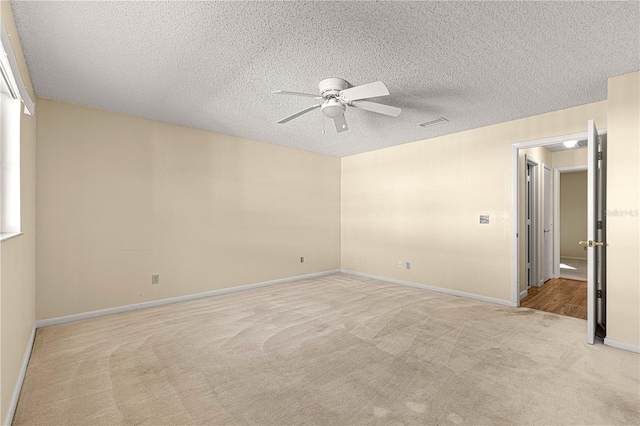 carpeted empty room with a textured ceiling and ceiling fan