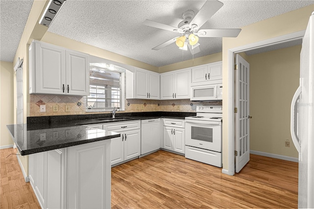 kitchen featuring kitchen peninsula, sink, white appliances, white cabinetry, and light hardwood / wood-style flooring