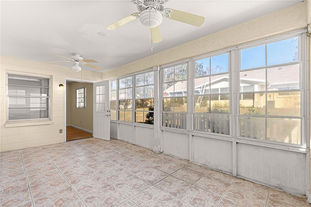 unfurnished sunroom with ceiling fan