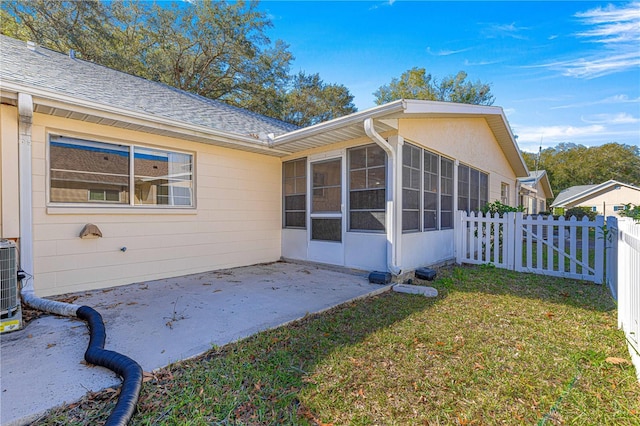 view of home's exterior featuring a patio area, a sunroom, and a yard