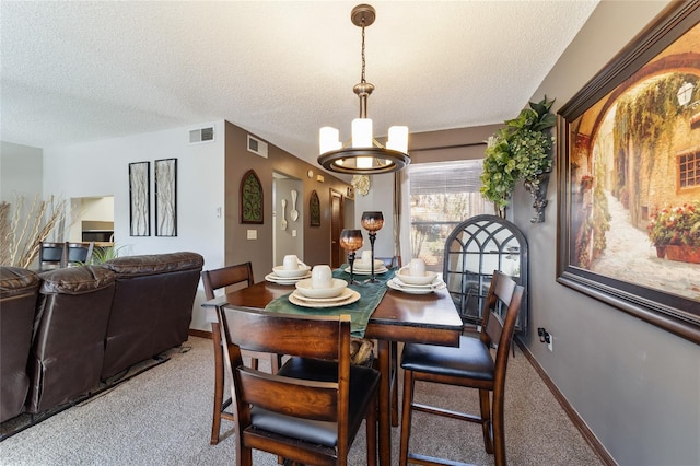 carpeted dining room with an inviting chandelier and a textured ceiling