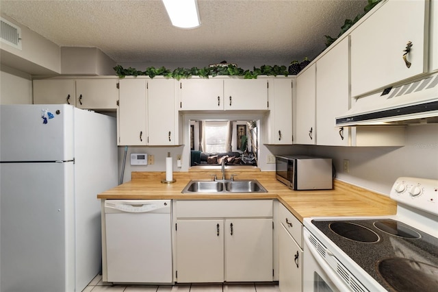 kitchen with sink, white appliances, white cabinetry, and a textured ceiling