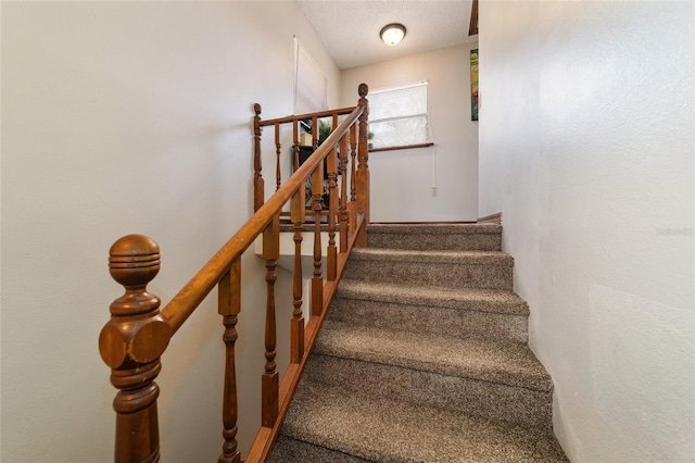 staircase with a textured ceiling