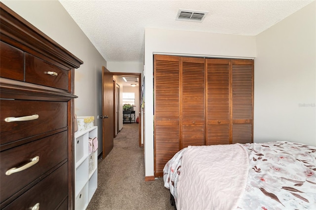 bedroom with a textured ceiling, a closet, and carpet