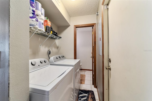 washroom featuring light tile patterned floors, independent washer and dryer, and a textured ceiling