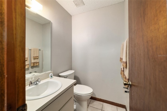 bathroom featuring a textured ceiling, toilet, tile patterned floors, and vanity