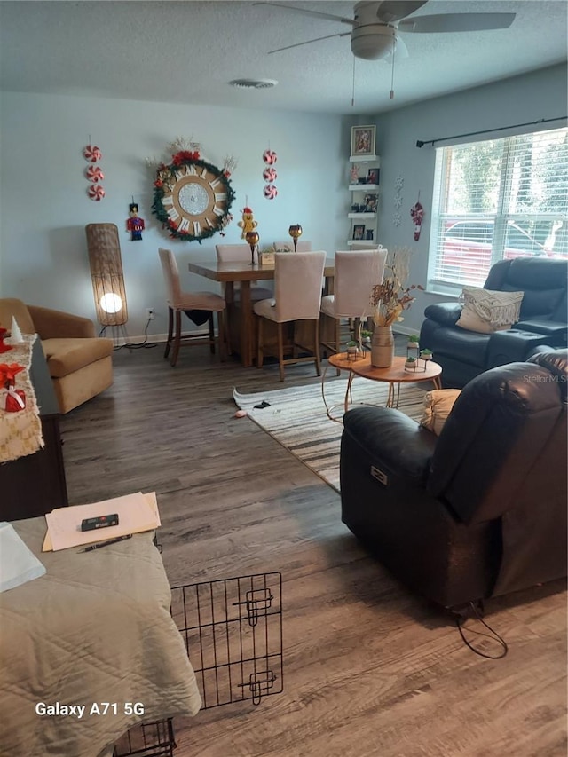 living room featuring a textured ceiling, ceiling fan, and hardwood / wood-style flooring