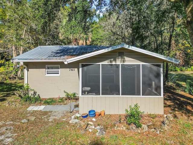 view of home's exterior with a sunroom