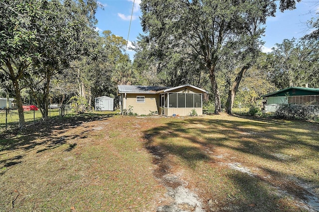 view of yard featuring a sunroom and a storage unit