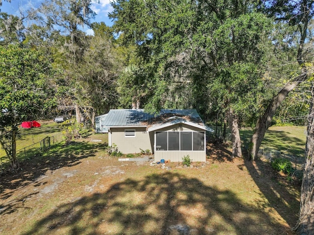 rear view of house with a sunroom and a lawn