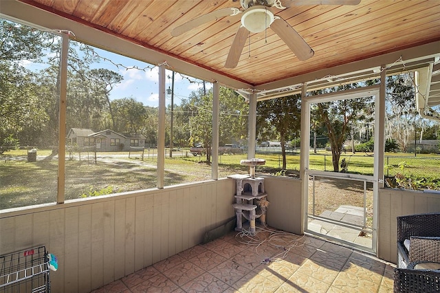 unfurnished sunroom with ceiling fan and wood ceiling