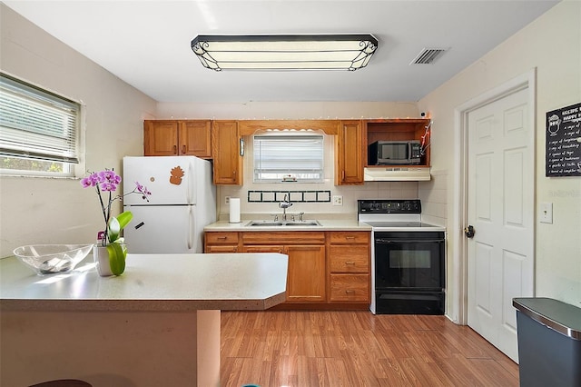 kitchen featuring white fridge, light hardwood / wood-style floors, backsplash, electric range, and sink